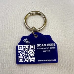 Foto asli QR Pet ID Tag biru dengan ring kait logam di atas kain
